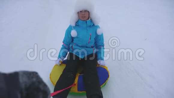 冬天女孩在雪碟上骑雪道在雪地上快乐地笑在雪橇上快乐的女人圣诞节视频的预览图