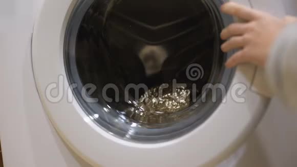 妇女从洗衣机洗衣特写中拿干净衣服的手视频的预览图