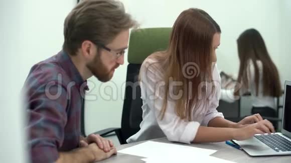 年轻漂亮的女人在电脑上给她的同事看一个项目他们讨论商业战略或计划创意创意视频的预览图