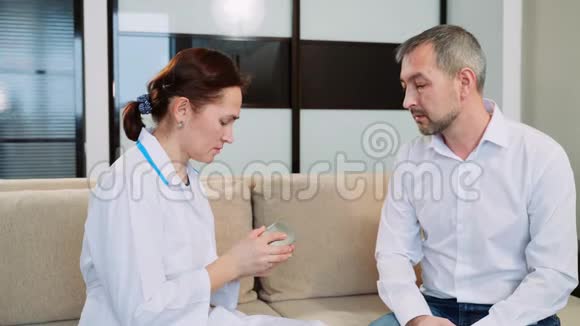 医生办公室里一个听力障碍人一位中年男子尝试使用助听器视频的预览图