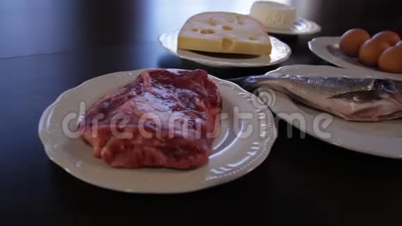 高蛋白食物生肉和鱼奶酪鸡蛋在单独的盘子里摄像机绕着这个向右移动视频的预览图