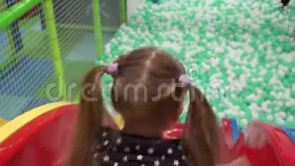 在儿童中心的操场上滑下滑梯女孩视频的预览图