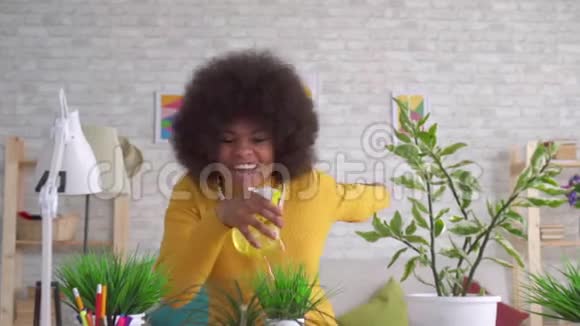 美丽的非洲裔美国妇女留着非洲发型打理花草视频的预览图