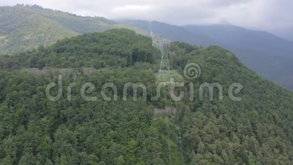 缆车舱在绿色的山林中行驶上面的无人机视频的预览图