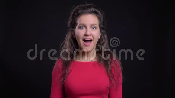 白种人妇女的肖像红色微笑着挥动手欢迎进入相机的黑色背景视频的预览图