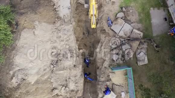 挖掘机和工人挖掘管道孔视频的预览图