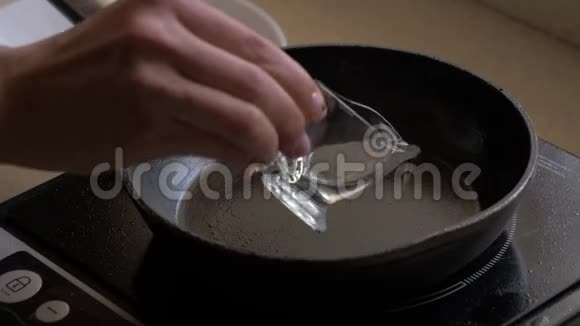 一只雌性手把油倒在煎锅里把切碎的香瓜放进平底锅里视频的预览图