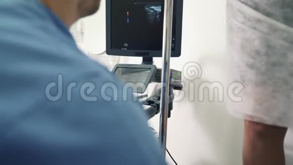 特写医生双手在声像仪屏幕上显示超声诊断结果视频的预览图