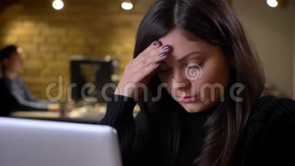 在笔记本电脑上工作时一位成年白种人深色头发的女商人感到烦恼和沮丧视频的预览图