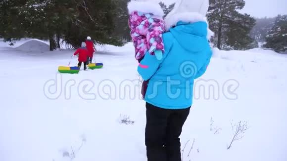 保姆和孩子们在冬季公园散步大家庭正在休息十几岁的女孩会滑雪橇妈妈带着小东西视频的预览图