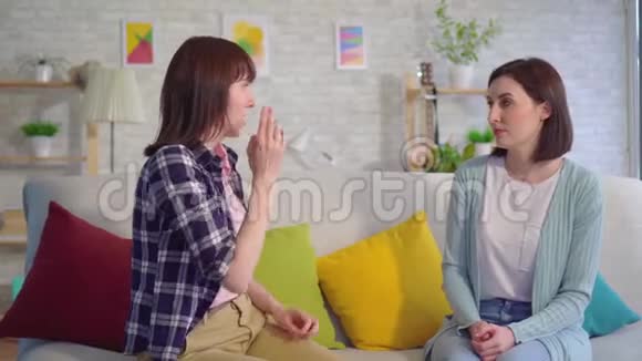 两个漂亮的聋哑年轻女子在客厅里近距离的说手语视频的预览图