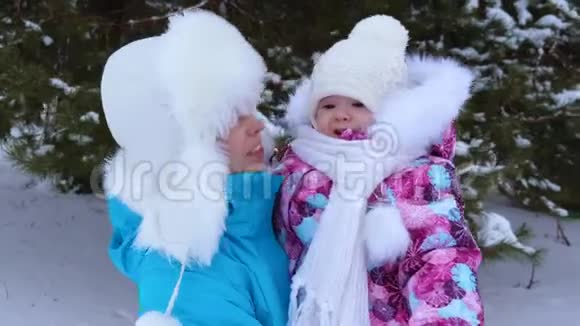 快乐的保姆和小女孩在冬季公园散步微笑特写视频的预览图