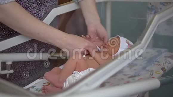 女人在家里换好的桌子上轻轻地照顾婴儿视频的预览图