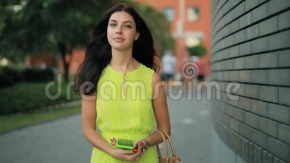 穿着绿色衣服走在市中心的女人视频的预览图