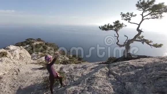 在克里米亚的一座山上年轻女子透过松树的树枝看着阳光夫人在视频的预览图