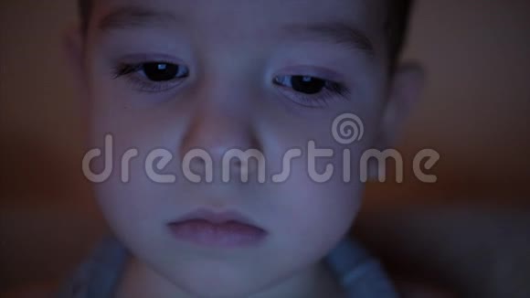 一个孩子脸看着一台平板电脑眼睛里有光反射视频的预览图