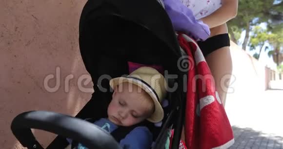 可爱的宝宝正在度假的婴儿车里睡觉视频的预览图