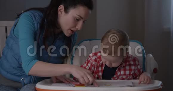 母子俩用彩色铅笔和蜡笔一起画画视频的预览图