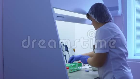 女化验员用试管和自动移液管进行医学检验视频的预览图