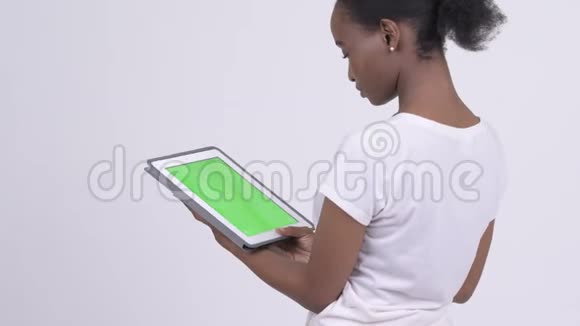 使用数码平板电脑观看非洲年轻美女的后视图视频的预览图