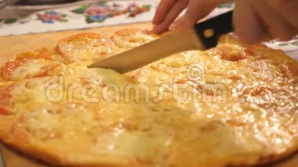 特写镜头一个人用披萨刀把一个意大利香肠披萨切成多片视频的预览图