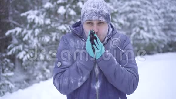 雪地背景下的冰冻人用智能手机打电话视频的预览图
