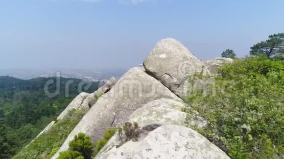 坐在山上岩石上的鸟瞰女孩视频的预览图