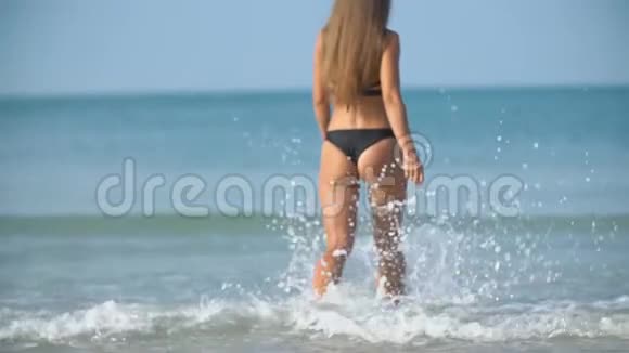 穿泳装的女孩走在海边视频的预览图