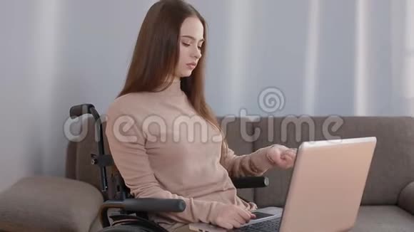 带手提电脑在家工作的残疾青年妇女视频的预览图