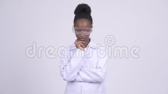 戴防护眼镜的年轻非洲女医生低头思考视频的预览图