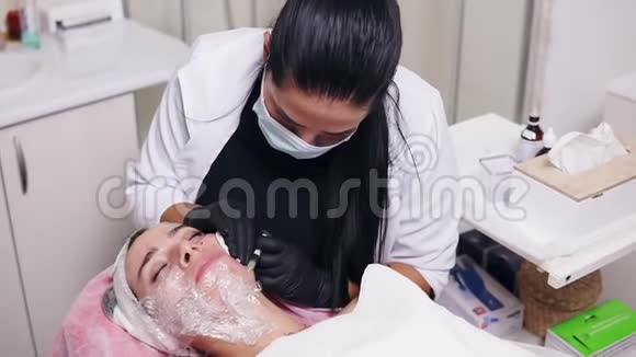 专业的美容师在面膜做多次注射在妇女脸颊在中间治疗生物重组和视频的预览图