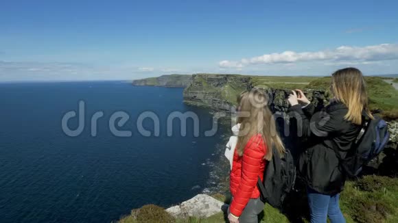 两位年轻女子欣赏爱尔兰莫赫悬崖的全景视频的预览图