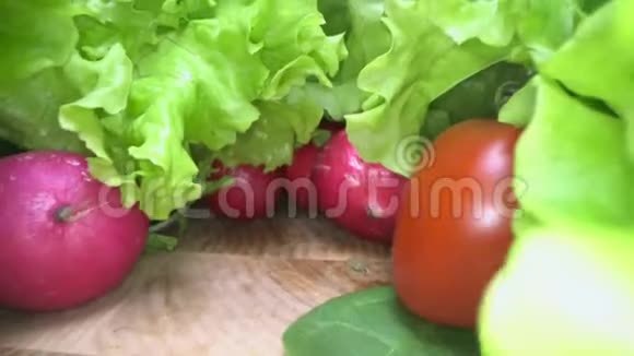 木桌背景上的土生土长和收获的蔬菜的多莉照片滑过新鲜的生菜沙拉西红柿萝卜视频的预览图