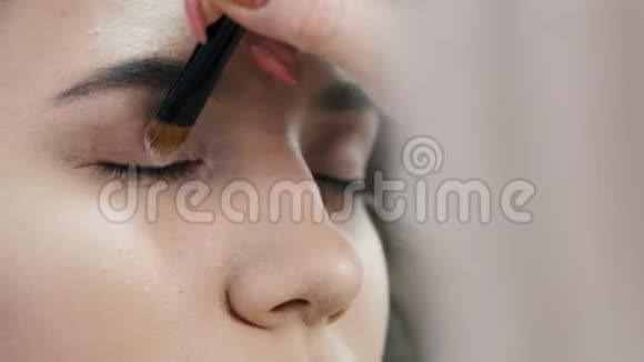化妆师的特写镜头用画笔描绘阴影视频的预览图