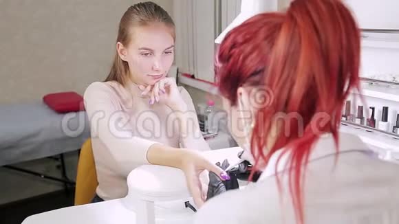 美容院的女美甲师用莱茵石装饰顾客的指甲视频的预览图