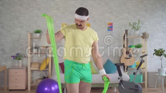 有趣的男人失败者在家里用橡皮筋锻炼身体视频的预览图