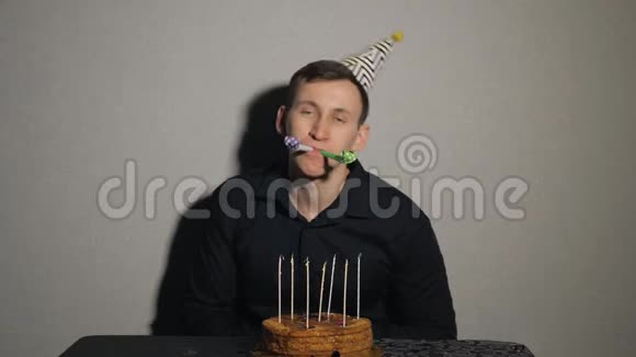一个年轻人拿着巧克力蛋糕和一支蜡烛玩派对吹箫视频的预览图