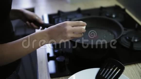 一个女人在煎锅里用热辣的黄油把一个新鲜的鸡蛋打碎洗澡后吃晚早餐腌制准备视频的预览图