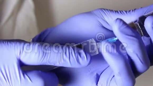 医生他的手用注射器把这个溶液注入一小瓶疫苗中混合药物准备视频的预览图