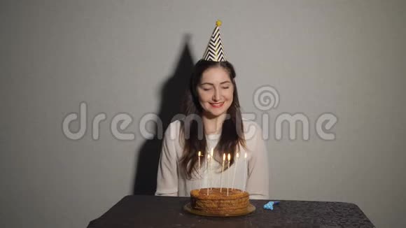 美丽的黑发少女许愿在生日巧克力蛋糕上吹蜡烛视频的预览图