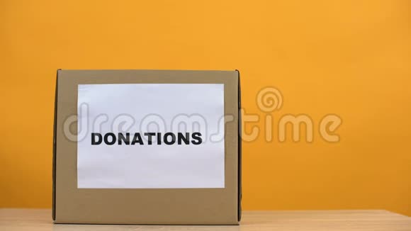 女性把衣服放在捐赠箱里放在桌子上社会活动家的善良帮助视频的预览图