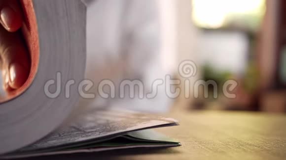 漂亮的年轻女人在咖啡馆里坐在木椅上放松和看书有选择的焦点视频的预览图