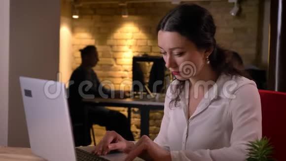 年轻的白种人女办公室职员在笔记本电脑上打字心烦意乱和困惑的特写照片视频的预览图
