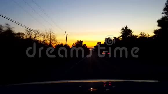 日落或日出时从汽车后的背面看农村公路从车辆后面的POV角度视频的预览图