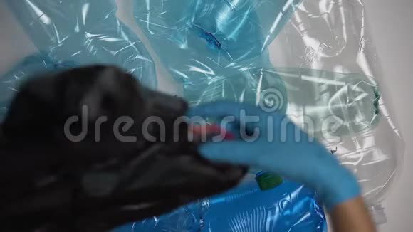 戴手套的人收集袋子里的旧塑料瓶危险的处置物视频的预览图