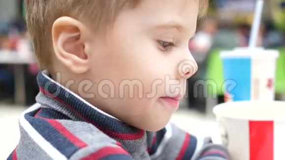 一个孩子在快餐店吃炸土豆在盘子里手举起来土豆片油煎视频的预览图