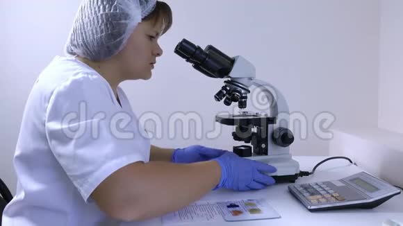 女化验员统一使用显微镜进行研究视频的预览图