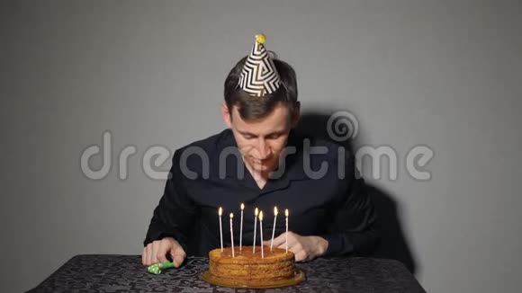 年轻人许愿在生日蛋糕上吹蜡烛视频的预览图