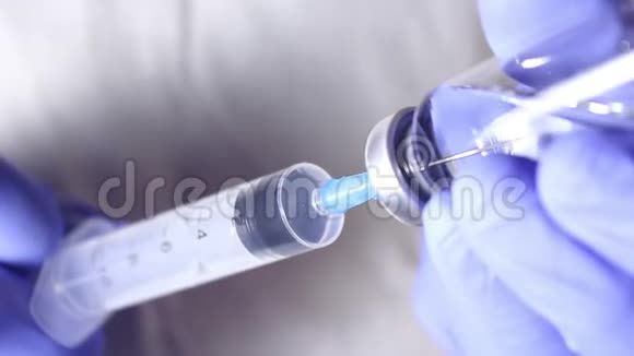 医生他的手把注射器装满疫苗为注射给病人做准备视频的预览图