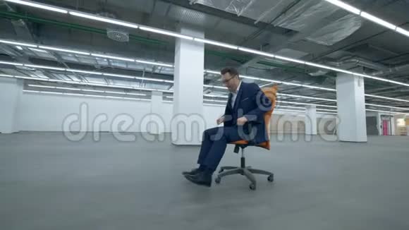 办公室经理坐在轮椅上穿过一个空荡荡的大厅视频的预览图